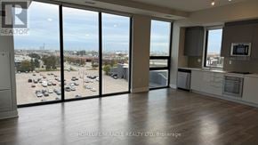 Vaughan (Concord) condo for rent - A spacious room with a view of a parking lot through large windows.