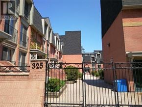 Toronto (Moss Park) townhouse for rent - A black gate leads to a brick building with the number 325 on it.