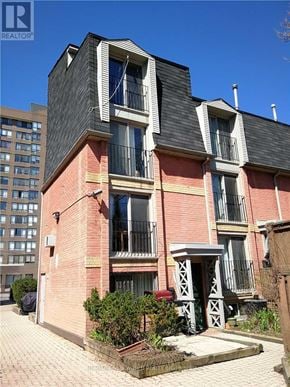 Toronto (Moss Park) townhouse for rent - A red brick building with a black roof and white trim.