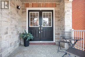 Milton (Ha Harrison) apartment for rent - A black door with a glass window is flanked by a stone wall and a brick wall.
