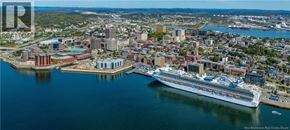 Saint John apartment for rent - A large cruise ship is docked at a port in a city.