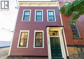 Saint John apartment for rent - A red building with a green door and windows.