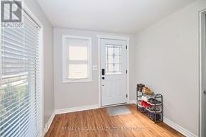 St. Catharines (Western Hill) apartment for rent - A hallway with a white door and a shoe rack with shoes on it.