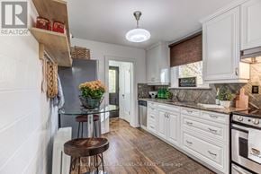 Toronto (The Beaches) apartment for rent - A kitchen with white cabinets and a glass island.