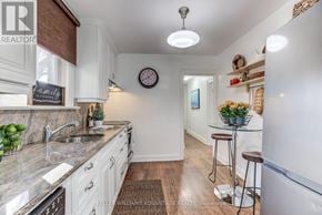 Toronto (The Beaches) apartment for rent - A kitchen with a marble countertop and white cabinets.