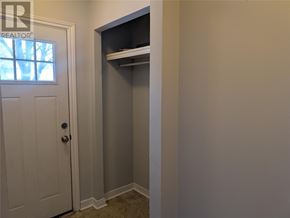 St. John's multi-family for rent - A white door is on the left of a room with a white wall and a white closet with shelves.