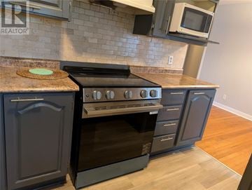 St. John's multi-family for rent - A modern kitchen with a black oven and microwave above it.
