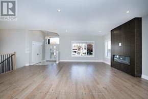 Port Colborne (Sugarloaf) apartment for rent - A spacious living room with a fireplace and a view of the backyard.