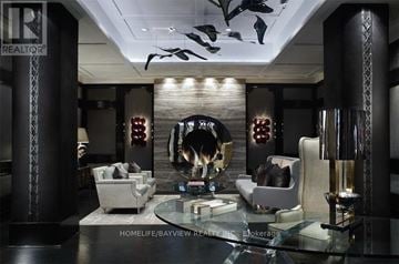 Toronto (Waterfront Communities) condo for rent - A modern living room with a glass table and a mounted shark head on the wall.