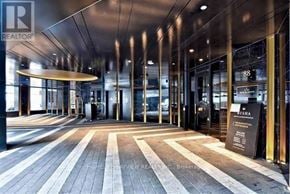 Toronto (Waterfront Communities) condo for rent - The lobby of a building with a wooden floor and glass doors.