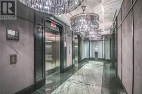 Toronto (Waterfront Communities) condo for rent - A hallway with a chandelier and elevator doors.
