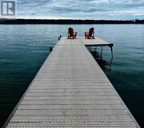 Barrie (South Shore) apartment for rent - Two red chairs are on a dock over a body of water.
