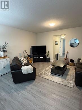London South (South W) townhouse for rent - A living room with a black couch, a television, and a rug.