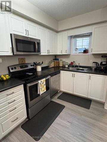 London South (South W) townhouse for rent - A kitchen with white cabinets and a black stove top.