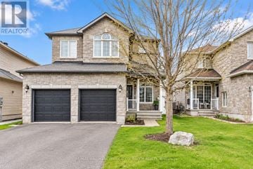 Clarence-Rockland apartment for rent - A large house with a grey driveway and a tree in front.