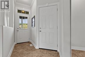 Clarence-Rockland apartment for rent - A hallway with a white door and a window with a view of a field.