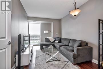 Mississauga (Clarkson) condo for rent - A living room with a grey couch and a television.