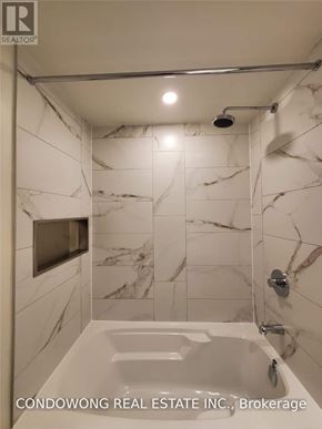 Toronto (Waterfront Communities) condo for rent - A white marble bathroom with a bathtub and a shower.