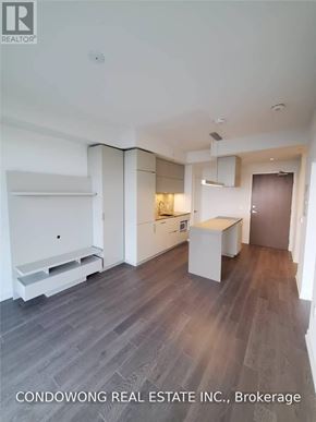 Toronto (Waterfront Communities) condo for rent - A modern kitchen with white cabinets and a wooden floor.