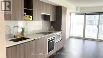Toronto (Waterfront Communities) condo for rent - A kitchen with wooden cabinets and a white countertop.