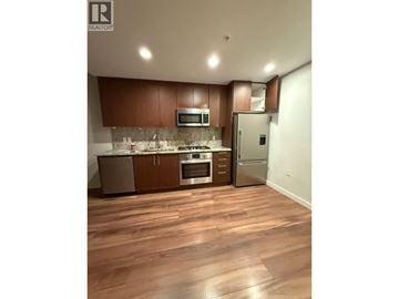 Richmond apartment for rent - A kitchen with wooden floors and brown cabinets.