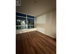 Richmond apartment for rent - A room with wooden floors and a window overlooking a cityscape.