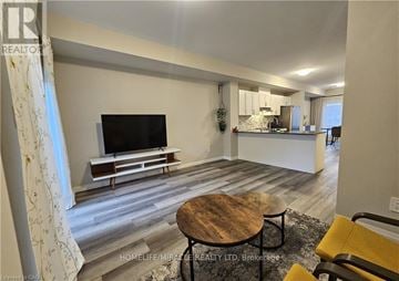 Brantford townhouse for rent - A living room with a television and a wooden coffee table.