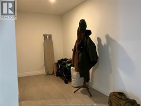 Windsor condo for rent - A room with a white wall and a brown suitcase.