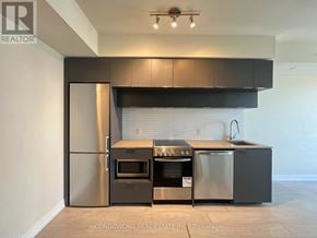 Toronto (Moss Park) condo for rent - A modern kitchen with stainless steel appliances and a black range hood.