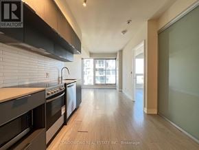 Toronto (Moss Park) condo for rent - A kitchen with black appliances and wooden floors.