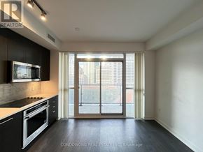 Toronto (Waterfront Communities) condo for rent - A modern kitchen with a stove top oven and microwave.