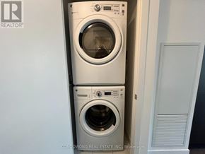 Toronto (Waterfront Communities) condo for rent - Two white front loading washing machines stacked on top of each other.