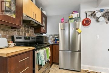 Toronto (East End-Danforth) apartment for rent - A kitchen with a stainless steel refrigerator and wooden cabinets.