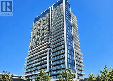 Richmond Hill (Langstaff) condo for rent - A tall building with many windows and balconies is under a clear blue sky.