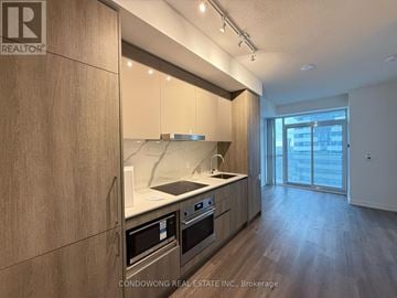 Vaughan (Vaughan Corporate Centre) condo for rent - A modern kitchen with wooden cabinets and stainless steel appliances.