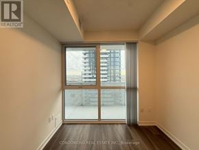 Vaughan (Vaughan Corporate Centre) condo for rent - A room with a large window and a view of a building outside.
