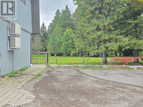 East Gwillimbury apartment for rent - A gravel driveway leads to a gate with a sign that says Royal LePage Realty Brokerage.