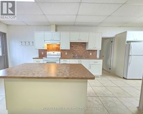 East Gwillimbury apartment for rent - A kitchen with white cabinets and a brown countertop.