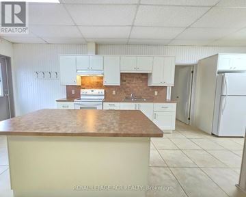 East Gwillimbury apartment for rent - A kitchen with white cabinets and a brown countertop.