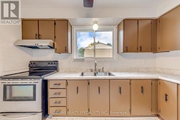 Hamilton (Beasley) townhouse for rent - A kitchen with brown cabinets and a stove top oven.
