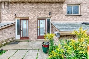 Hamilton (Beasley) townhouse for rent - A house with a red door and a green trash can in front.