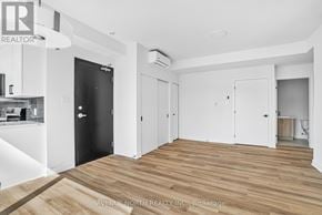 Ottawa multi-family for rent - A spacious room with wooden flooring and white walls.