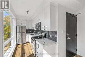 Ottawa multi-family for rent - A modern kitchen with stainless steel appliances and white cabinets.