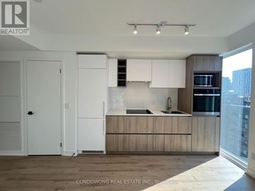 Toronto (Moss Park) condo for rent - A kitchen with white cabinets and a wooden counter.