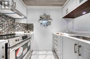 Toronto (Newtonbrook East) condo for rent - A kitchen with a stove top oven and a backsplash of tiles.