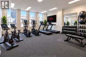 Windsor condo for rent - A gym room with a row of treadmills, exercise bikes, and a row of dumbbells.