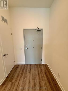 Welland (Broadway) condo for rent - A room with a white door and a brown floor.