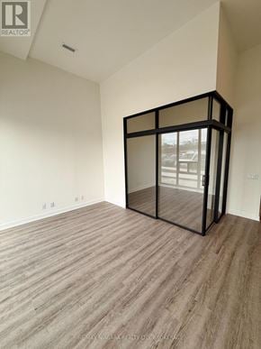 Welland (Broadway) condo for rent - A room with a wooden floor and a glass block wall.