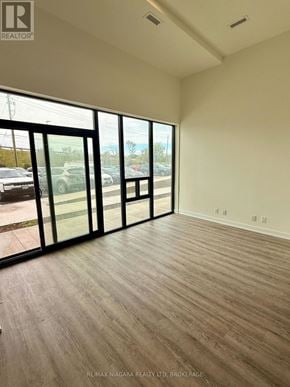 Welland (Broadway) condo for rent - A room with a large window and wooden flooring.