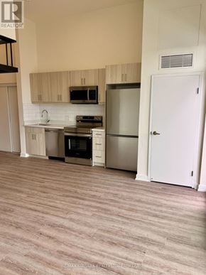 Welland (Broadway) condo for rent - A kitchen with a refrigerator, oven, and microwave.